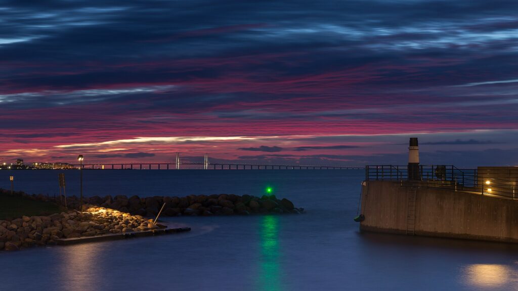 Öresundsbron i solnedgång sedd från Malmös kust
