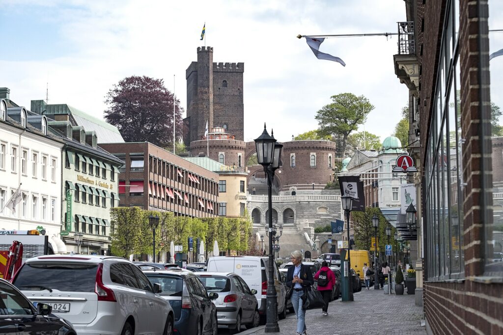 Gågångare på Stortorget i Helsingborg med Kärnan i fonden